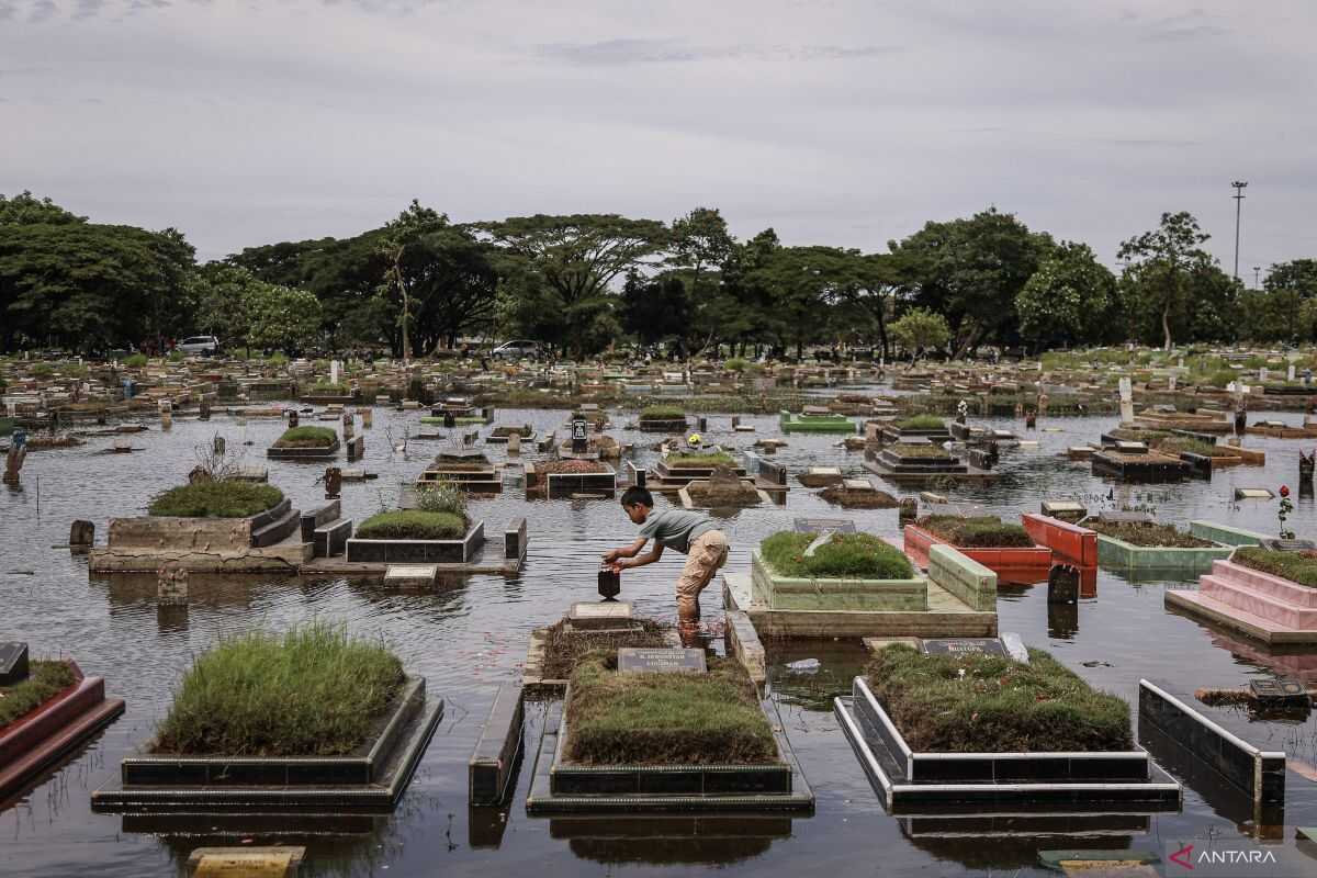 Flooded public cemetery fails to deter residents from visiting family graves ahead of Ramadan