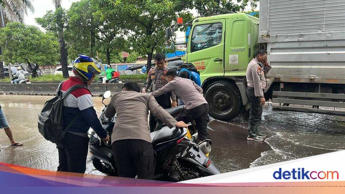 Flooding on Daan Mogot Road in West Jakarta as Police Help Push Stalled Vehicles