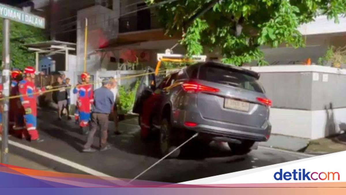 Learning to drive ends in disaster as car sinks into an uncovered drain in East Jakarta