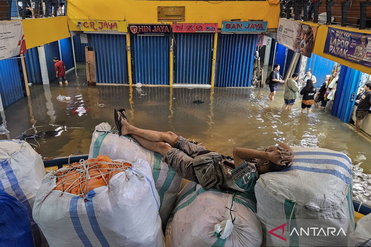Floodwaters flow through Cipulir Market in South Jakarta