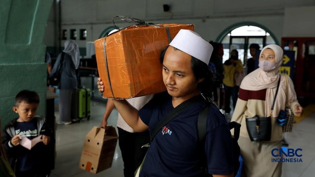 Revellers Carry Cardboard Boxes in Droves as They Return to Jakarta