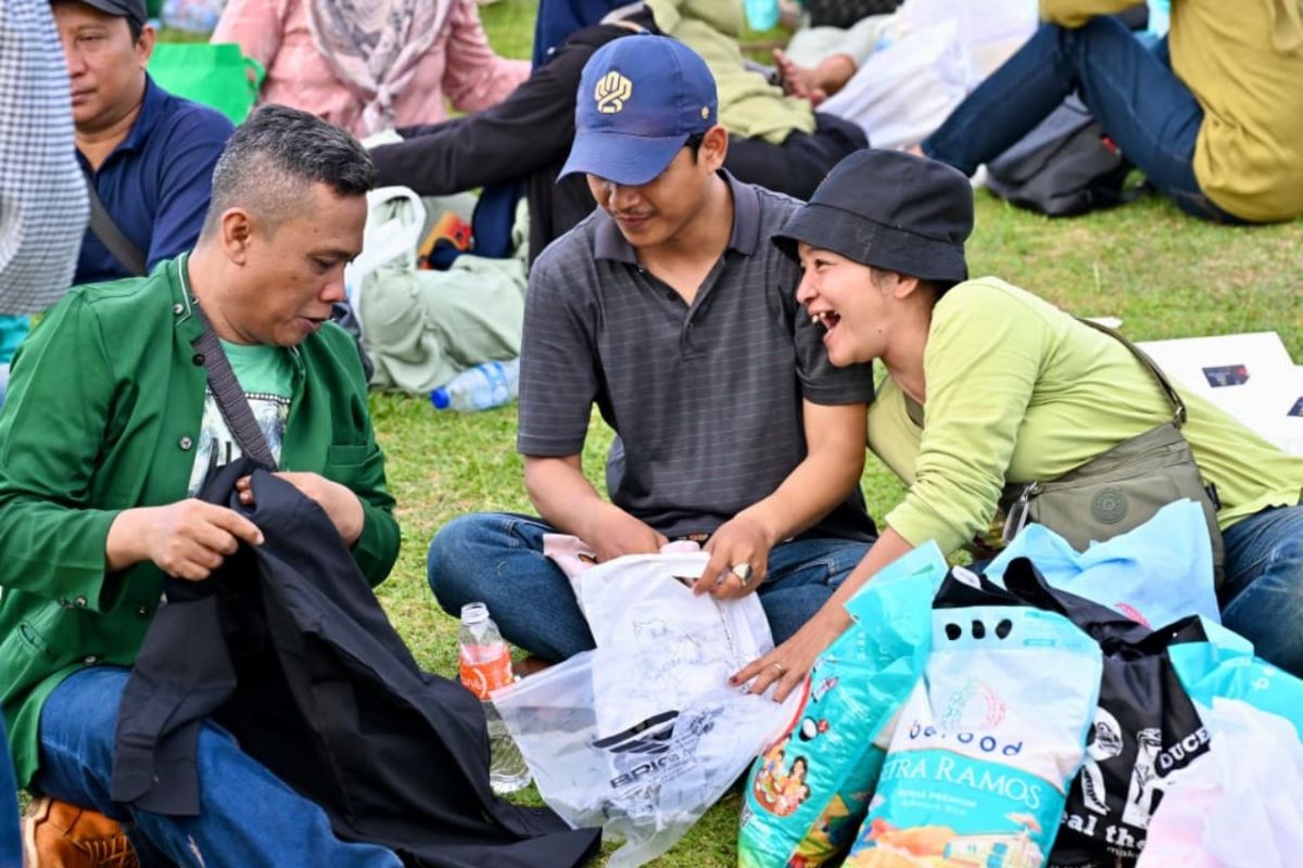 Resident opens food aid package at People's Bazaar at Monas