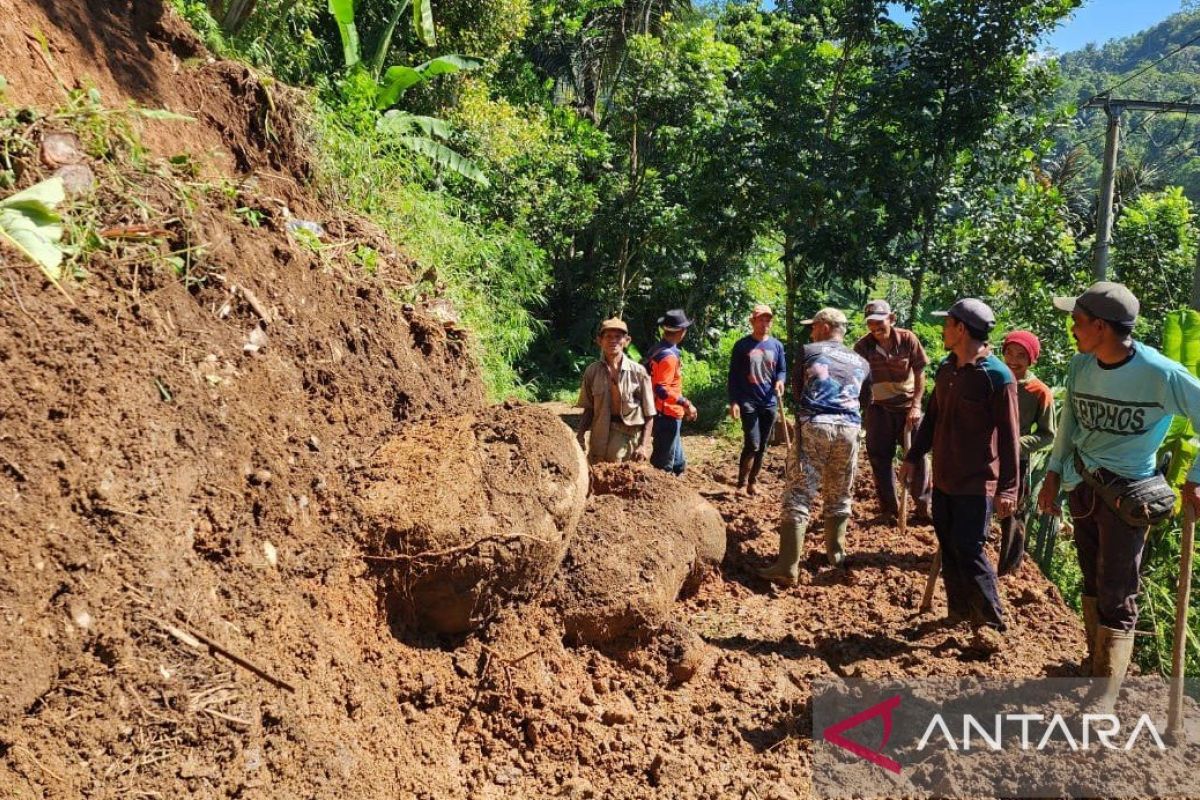 Officials and residents attempt to clear landslide-blocked road in Cidaun