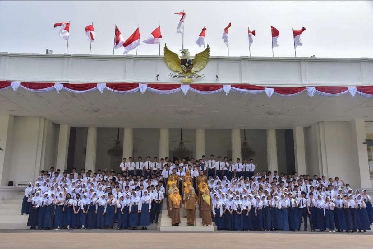 Students from SMPN 60 Jakarta examine Paspampres uniforms and weapons at the Palace