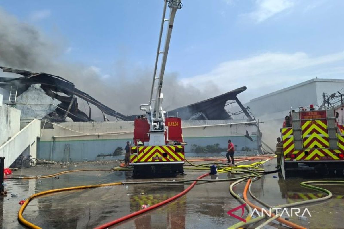 Thick black smoke still billowing from burning plastic warehouse in Cengkareng