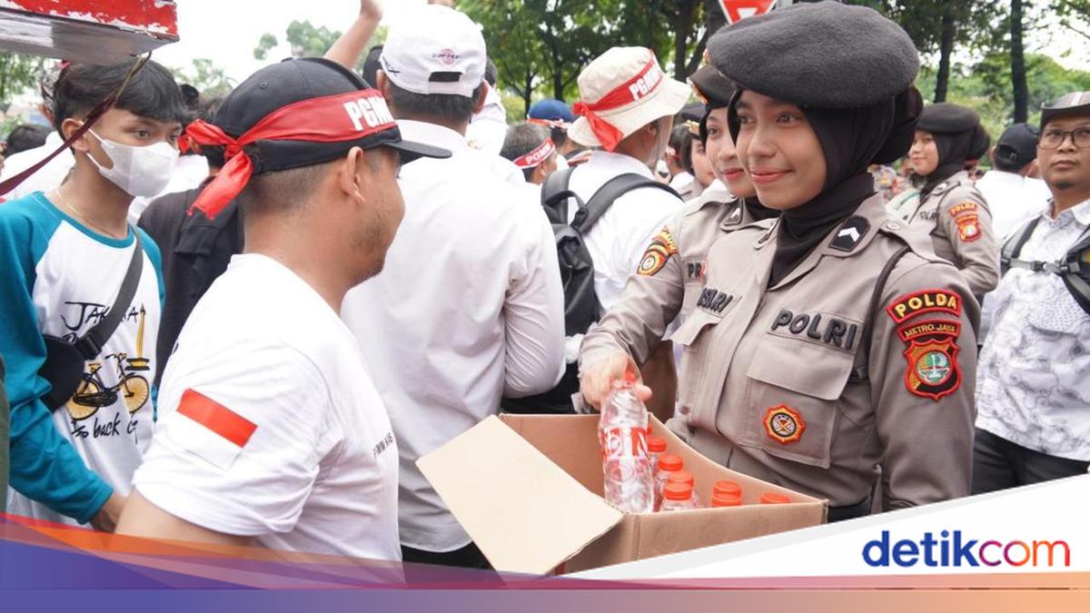 Policewomen Distribute Bottled Water to Demonstrators at the Honorary Teachers' Protest Outside the DPR