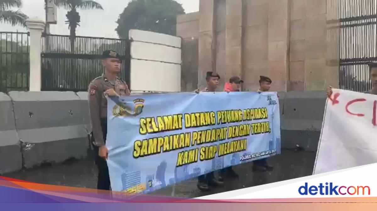 Police Guard Demonstration at DPR Building Amidst Rain