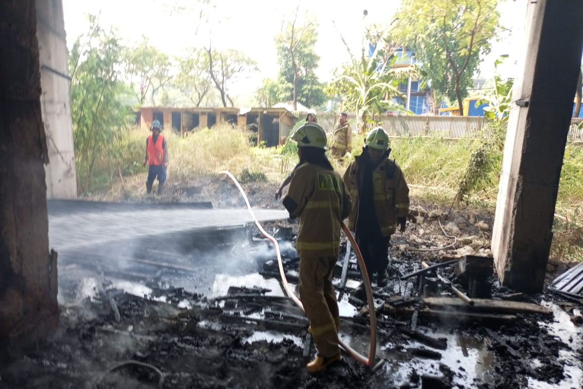 Firefighters extinguish warehouse blaze involving wood and cardboard piles in North Jakarta