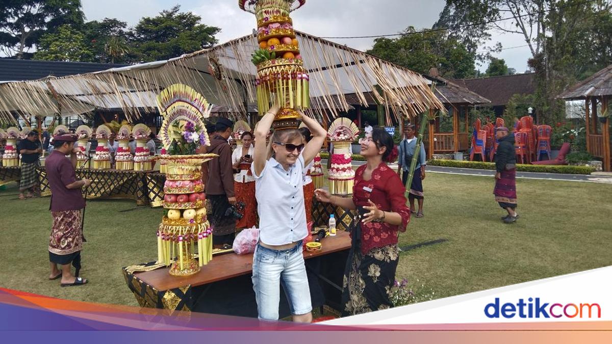 Foreign Tourists Enthusiastically Try Carrying Gebogan at Ulun Danu Beratan Festival