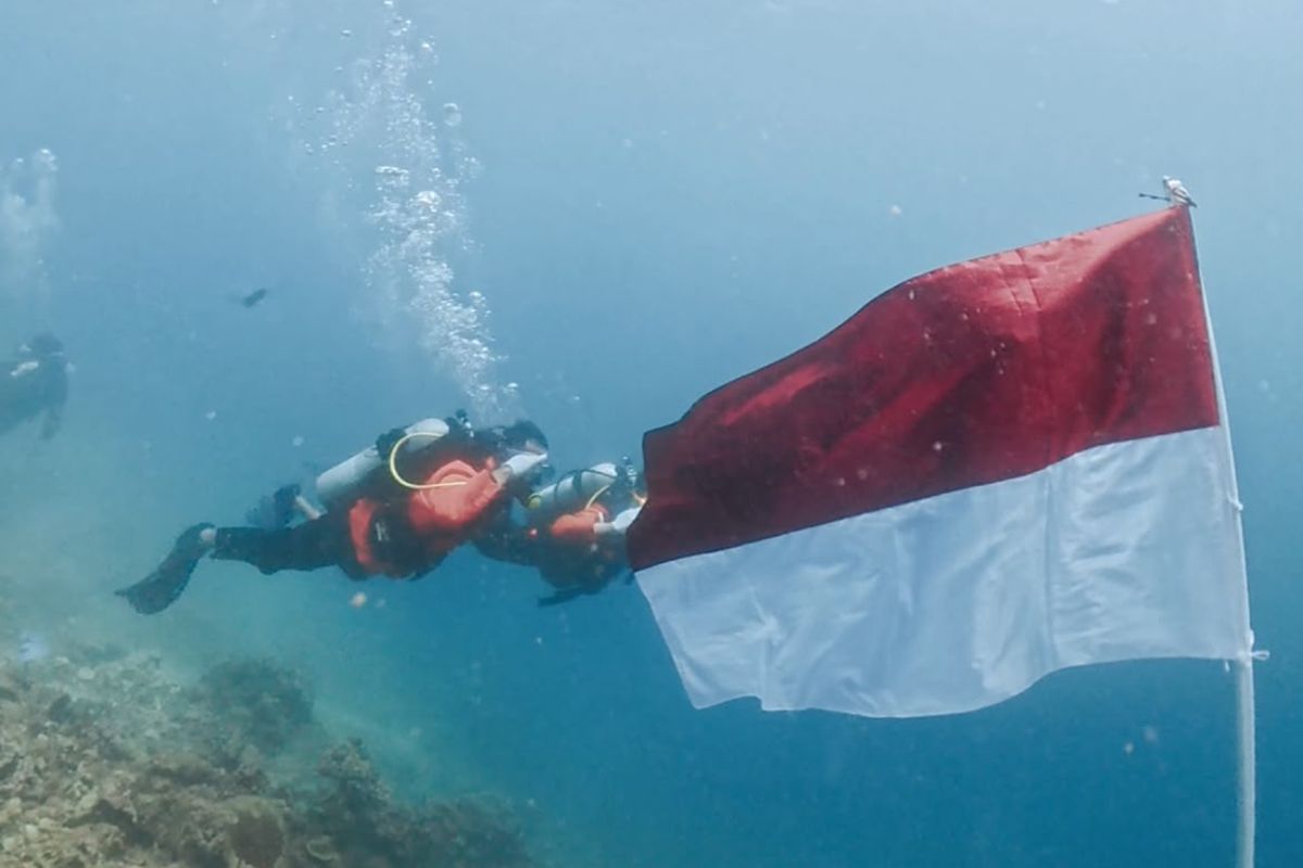 23 divers raise Red and White flag underwater in Kupang