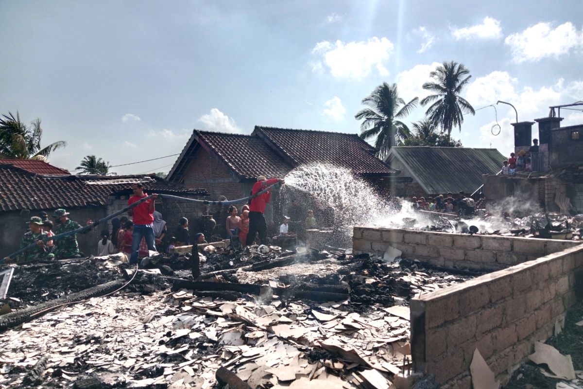 Officers clear debris from fire at Sade traditional village in Lombok